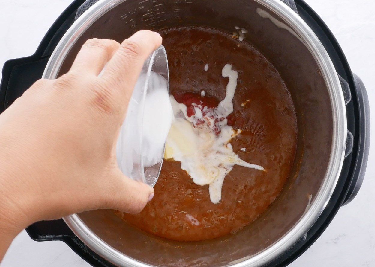 Cornstarch mixed with water being poured into Instant Pot.