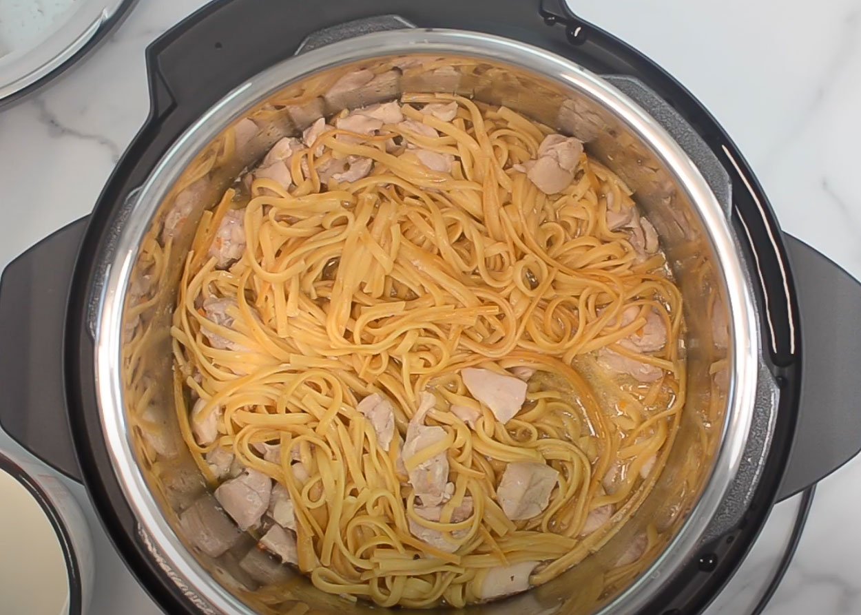 Chicken pieces and pasta in Instant Pot.
