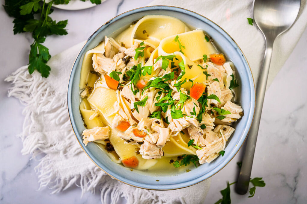 instant pot chicken soup with carrots and parsley garnish