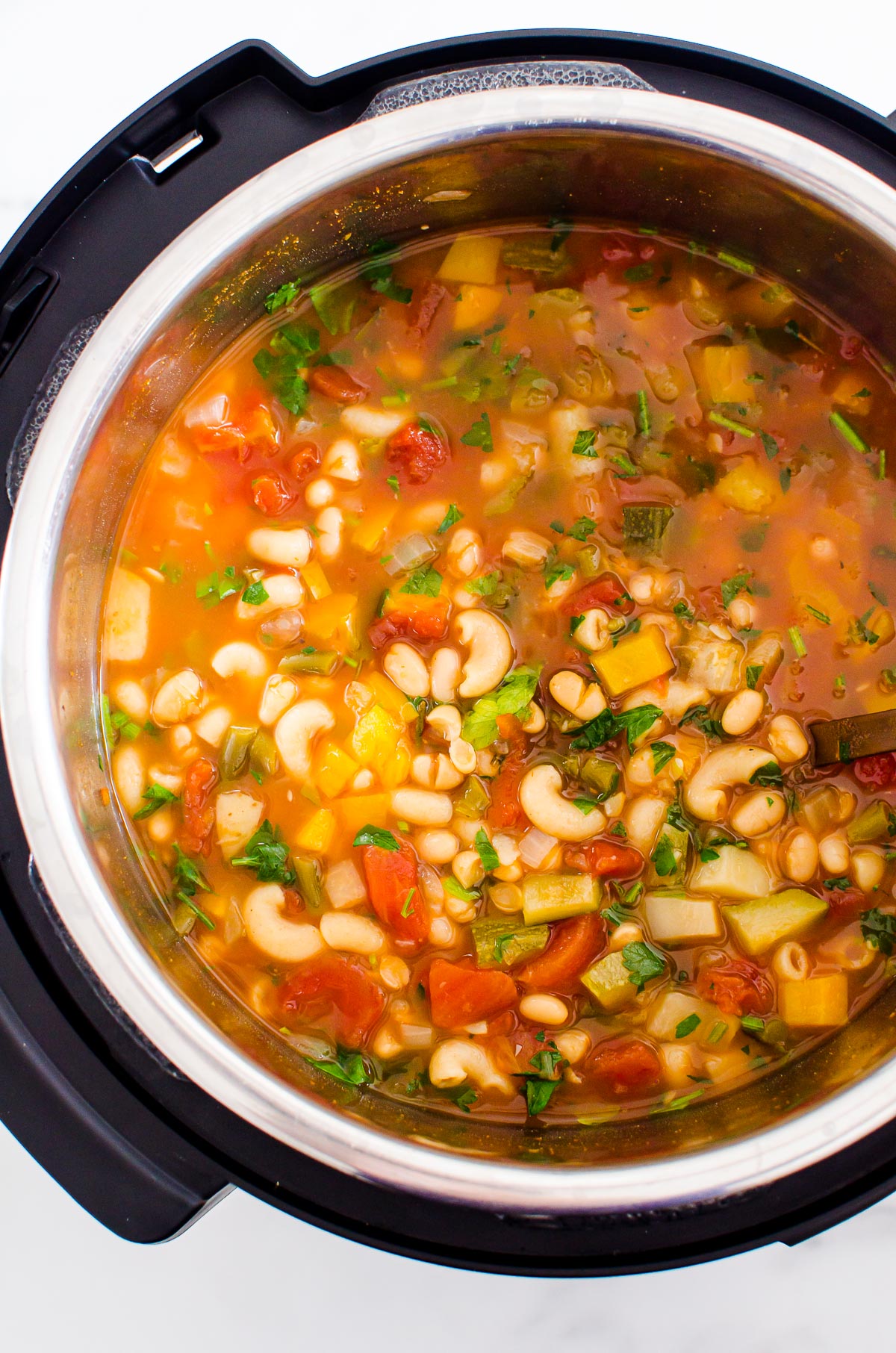 Instant Pot minestrone soup garnished with parsley.