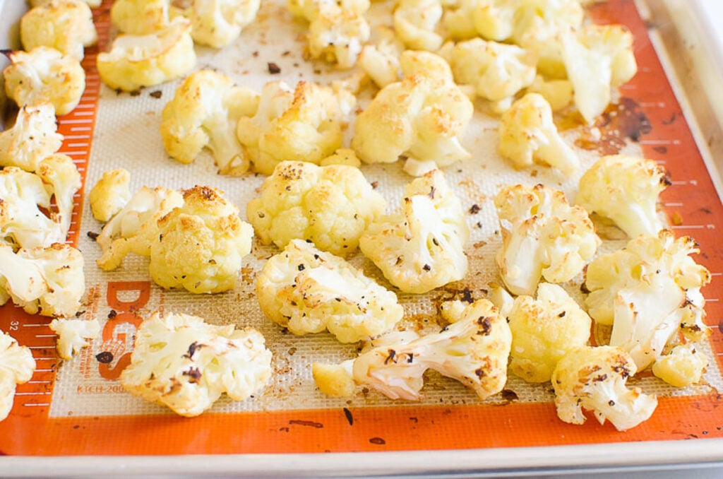 parmesan cauliflower bites roasting in oven on silpat lined pan