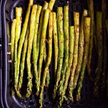 Asparagus in an air fryer basket.