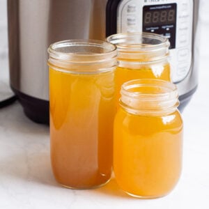 instant pot chicken stock in three jars cooling down