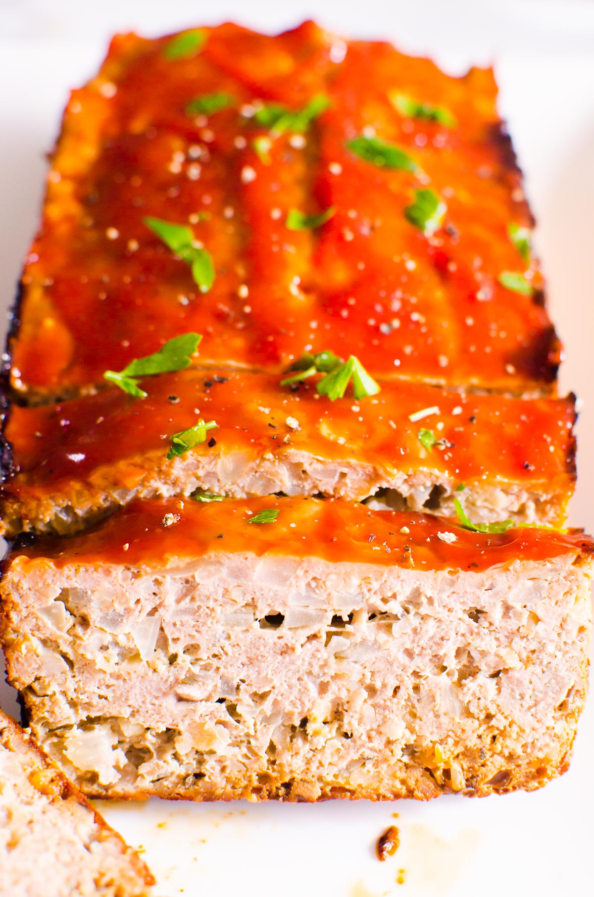 Turkey meatloaf sliced  and garnished with parsley.