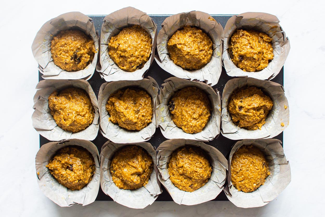Unbaked muffins with oat bran in muffin pan.