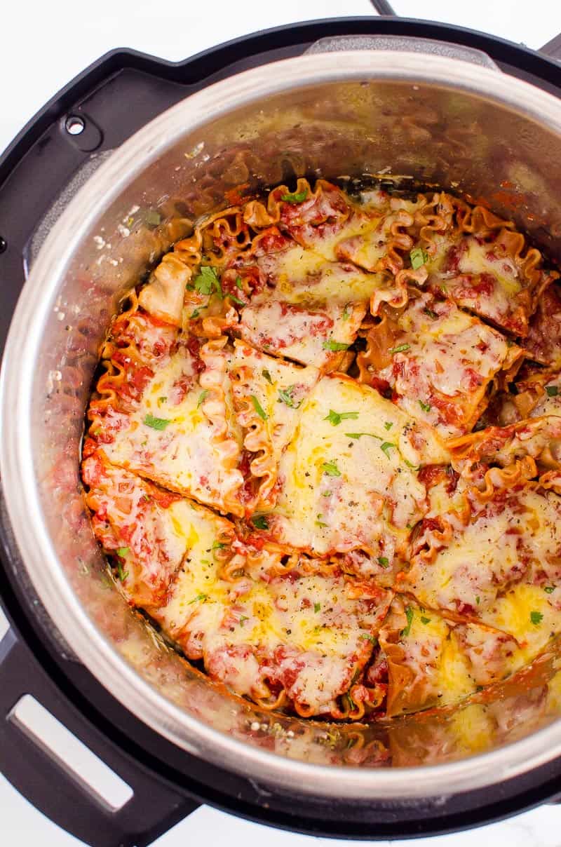 Lasagna topped with cheese inside an Instant Pot. 