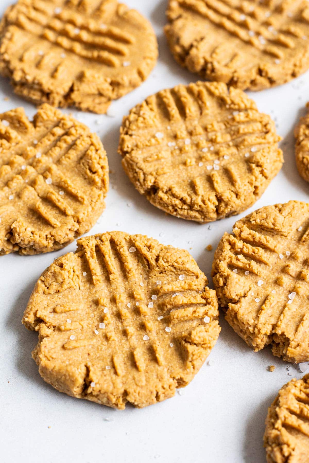 healthy peanut butter cookies with criss cross marks and sprinkle of salt