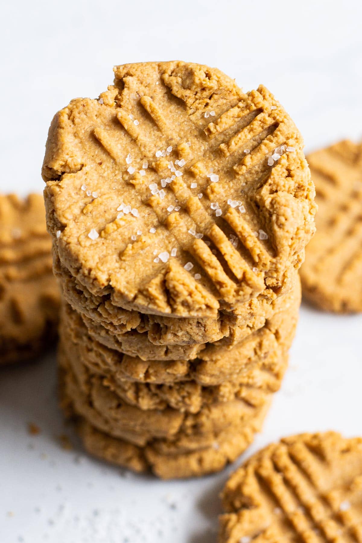A stack of healthy peanut butter cookies sprinkled with sea salt.