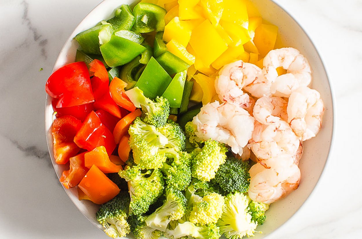 Shrimp, broccoli and peppers in a bowl.