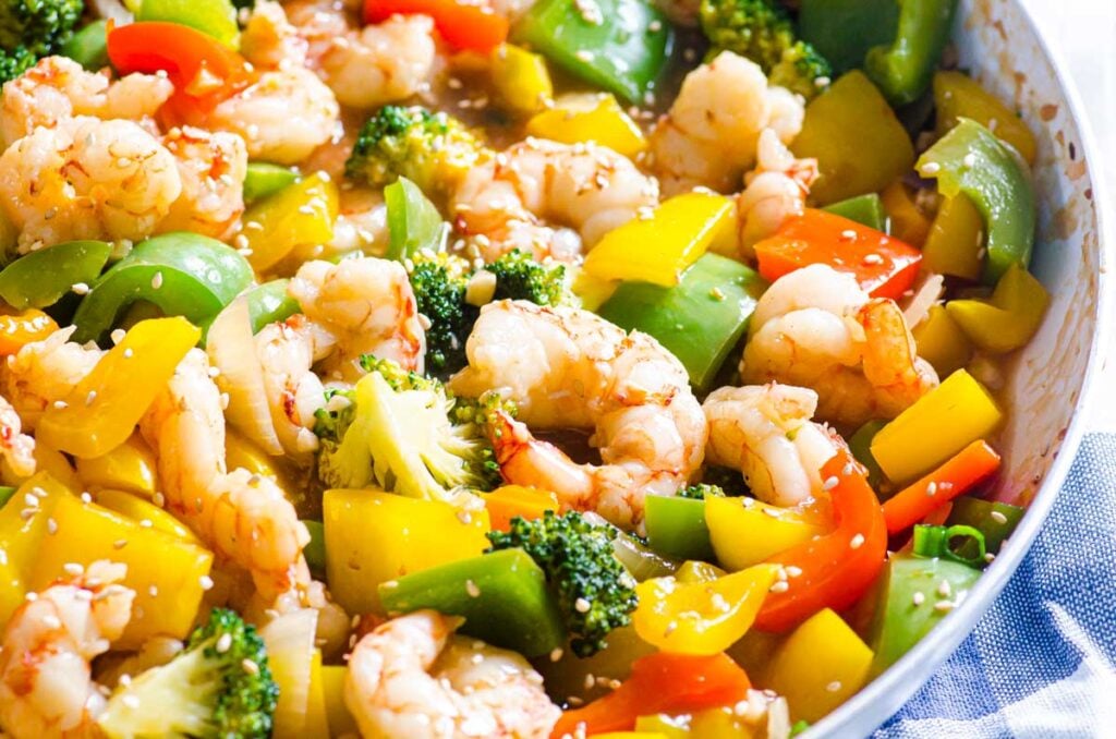 shrimp broccoli and bell peppers in a stir fry skillet