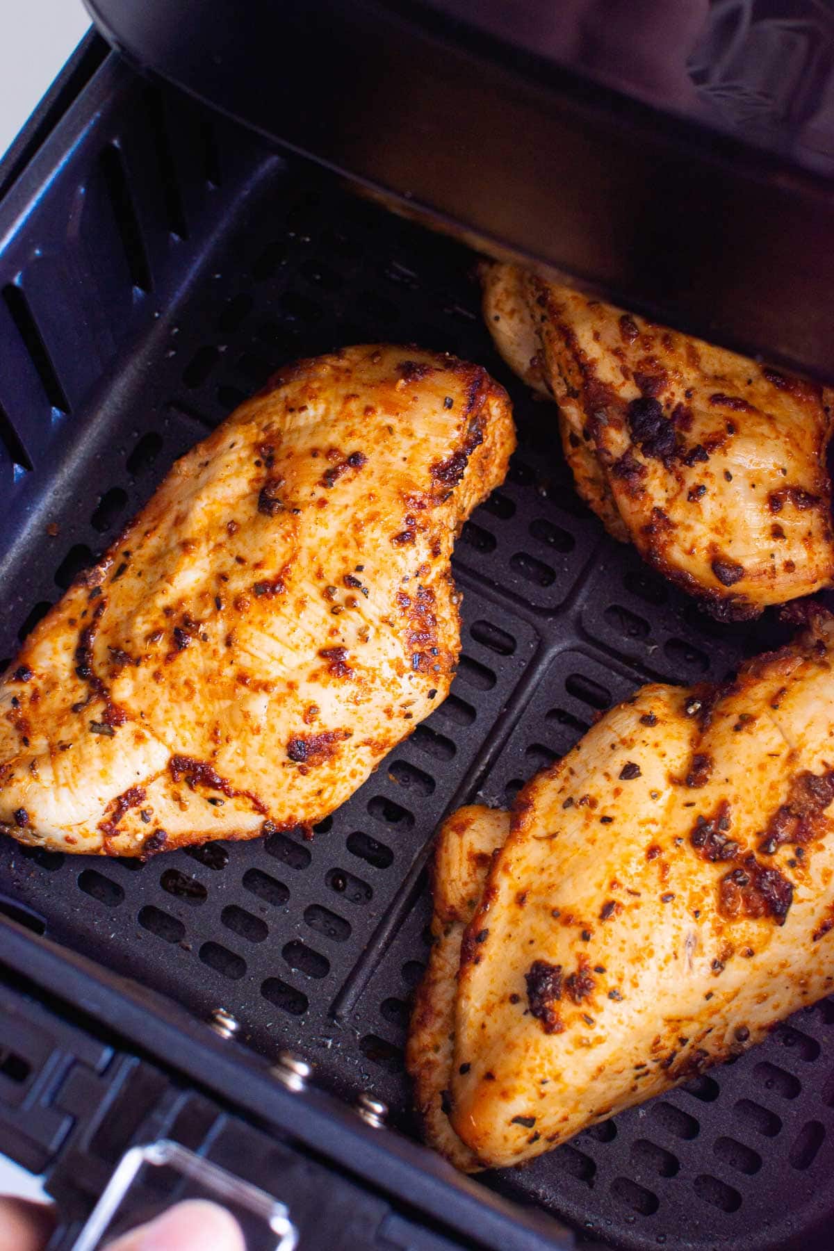Three chicken breasts in air fryer.