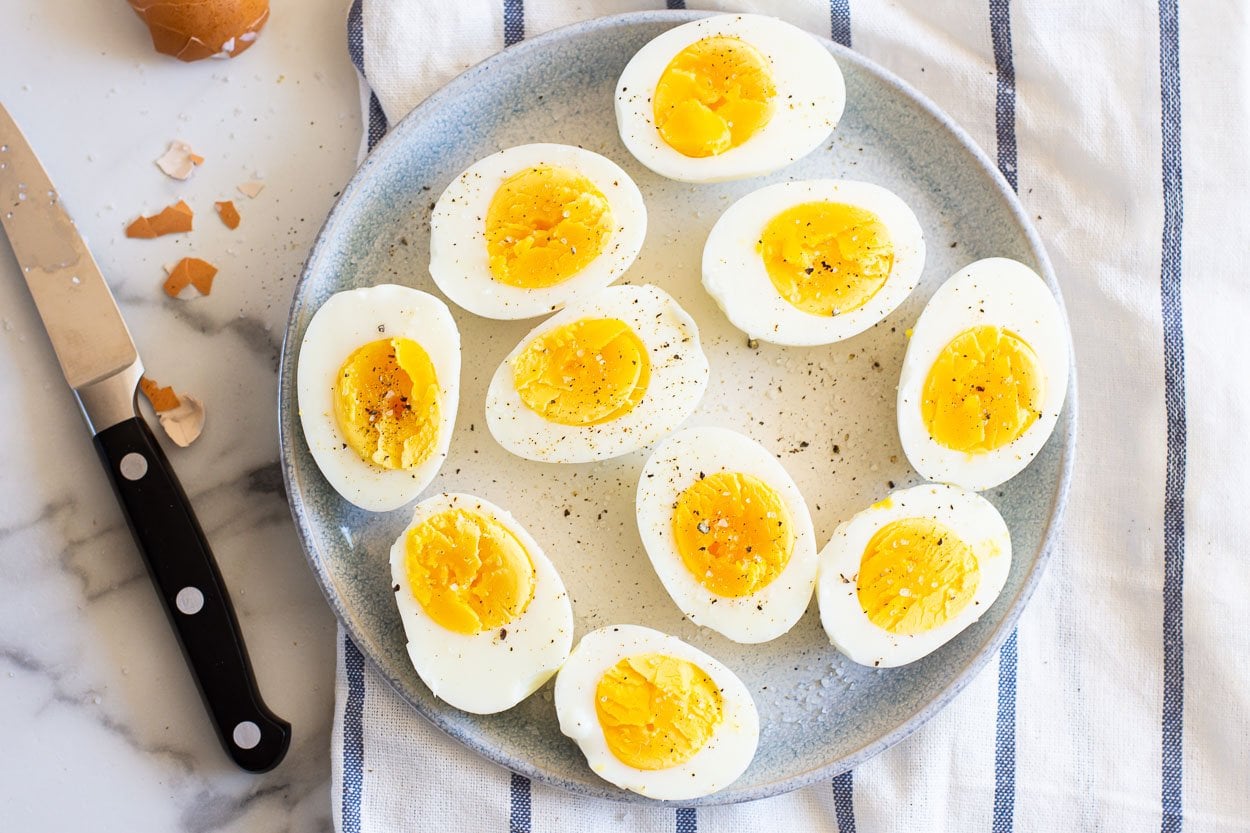 A plate of air fryer hard boiled eggs that are cut in half.