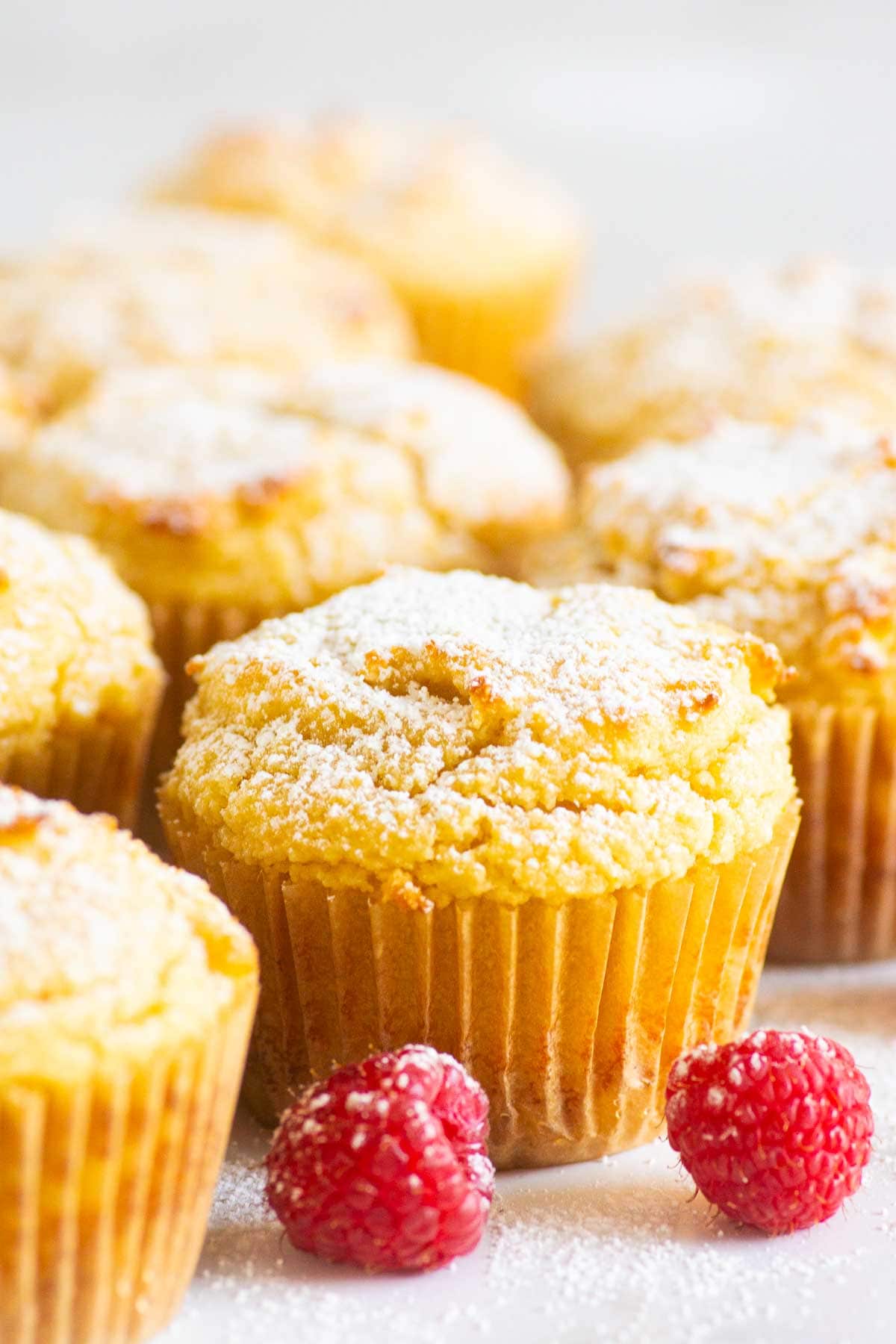 Almond flour muffins in paper liners with fresh raspberries.