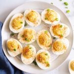 Healthy deviled eggs on a plate for serving with a blue linen.