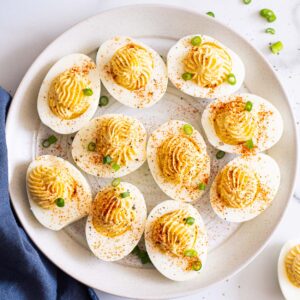 Healthy deviled eggs on a plate for serving with a blue linen.