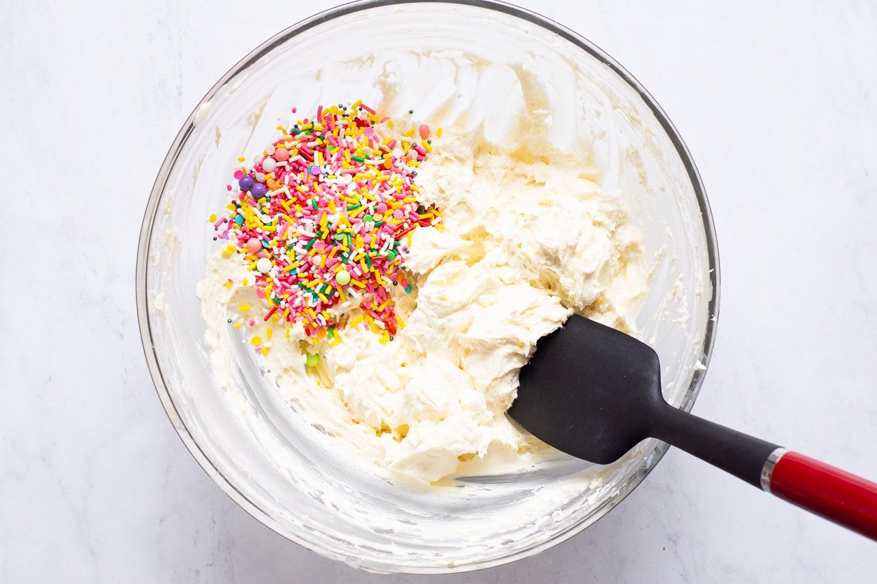 Frosting in a bowl with sprinkles.