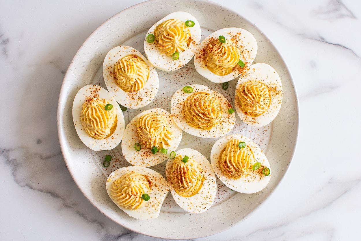 Healthy deviled eggs with garnish on plate for serving.