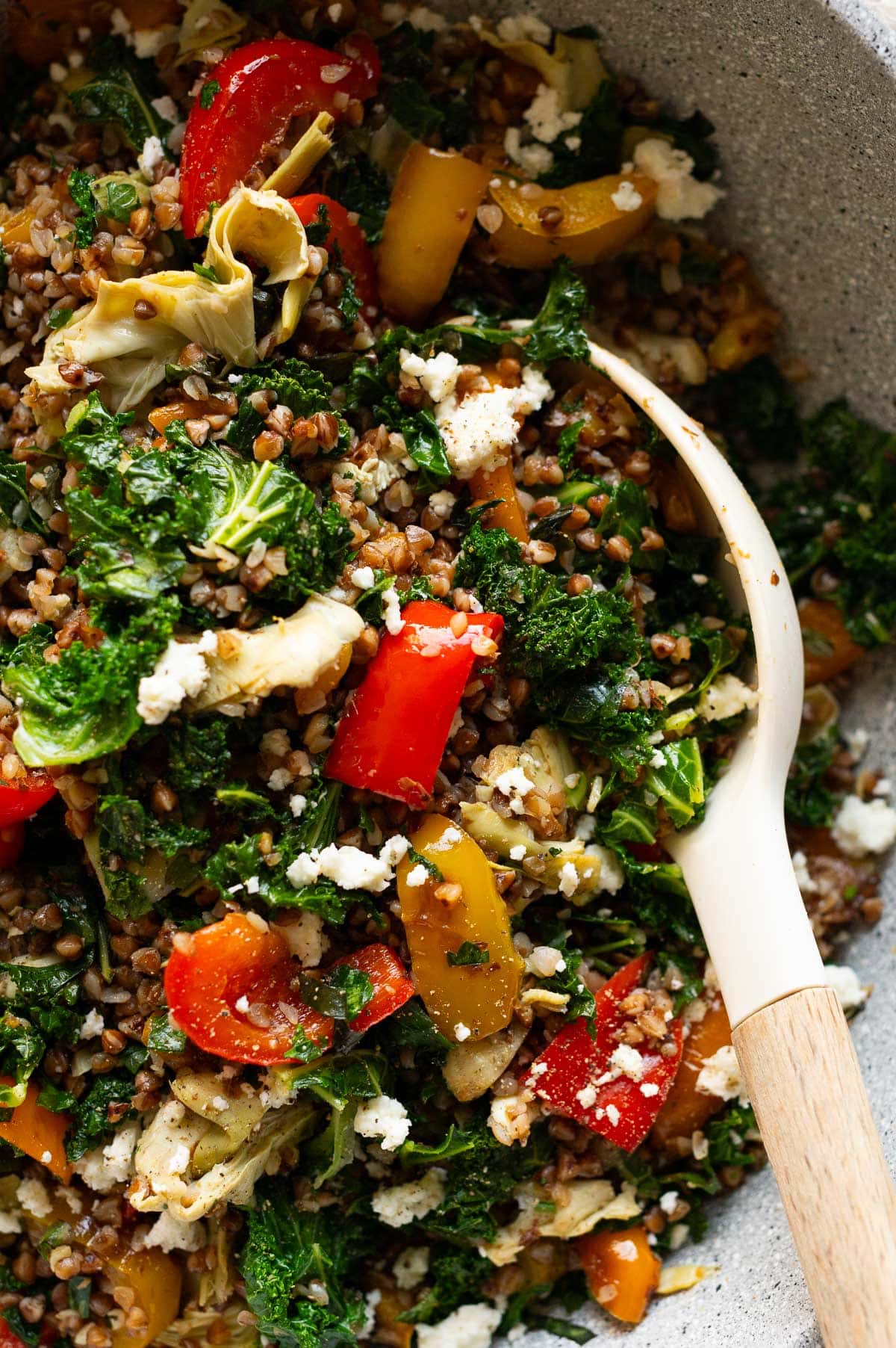 Close up of buckwheat stir fry with kale, bell pepper, artichoke and feta.