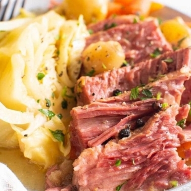 Corned beef on a plate with cabbage and potatoes.