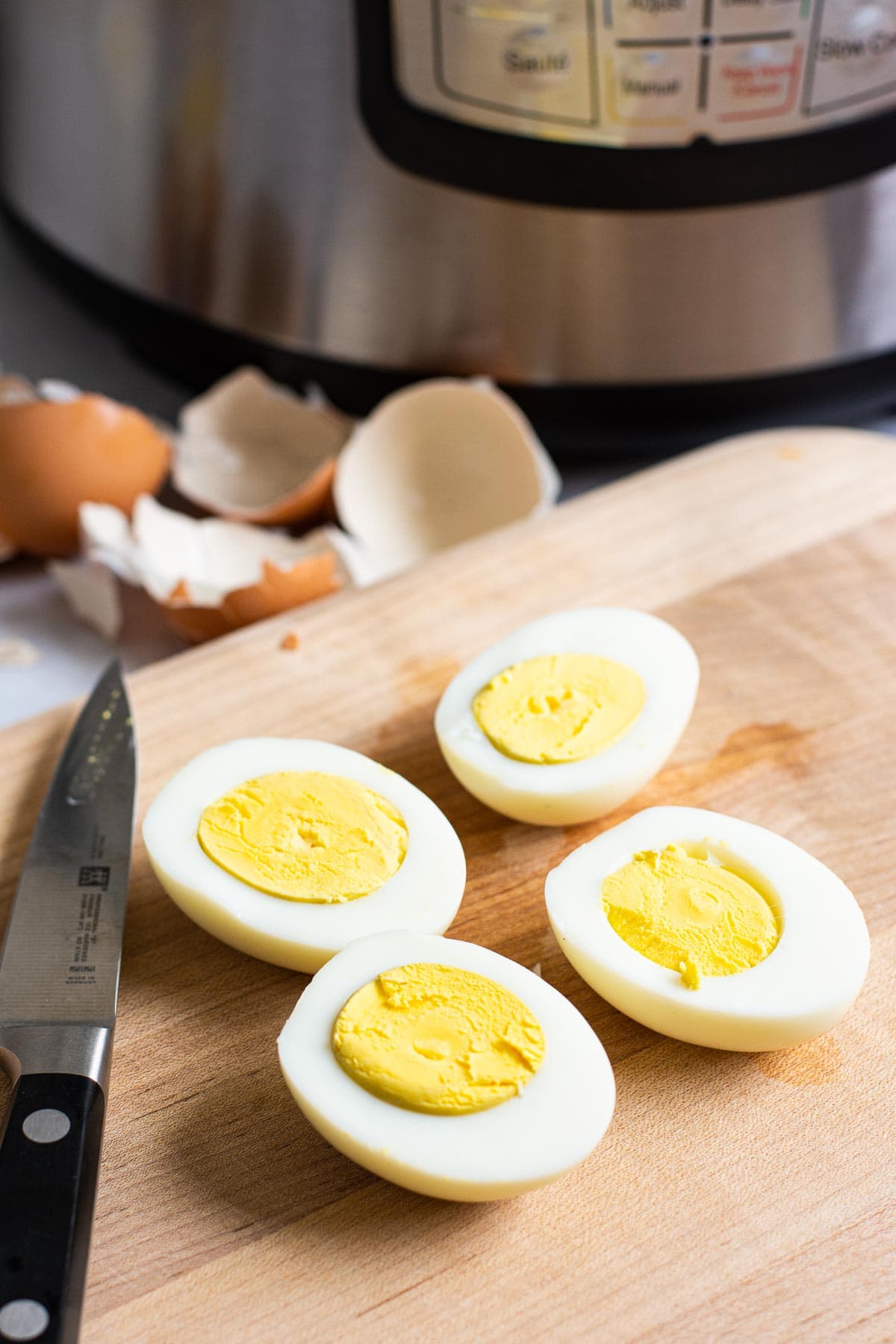 2 sliced Instant Pot hard boiled eggs on a cutting board.