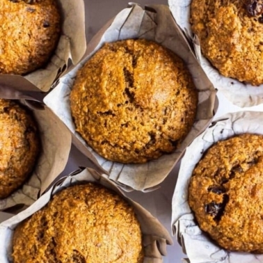 Looking down at oat bran muffins parchment paper liners.