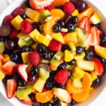 Healthy fruit salad with a honey lemon dressing in a bowl.