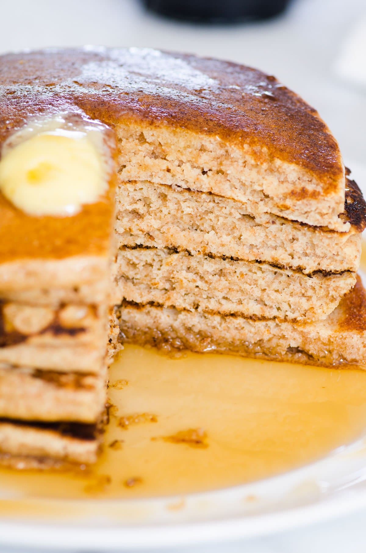 A stack of whole wheat pancakes cut through showing fluffy texture.