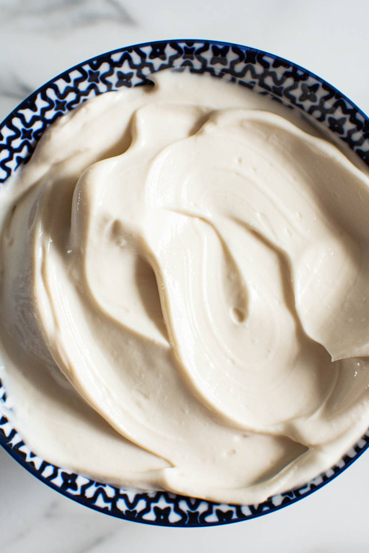 Close up of healthy Greek yogurt frosting in blue bowl.