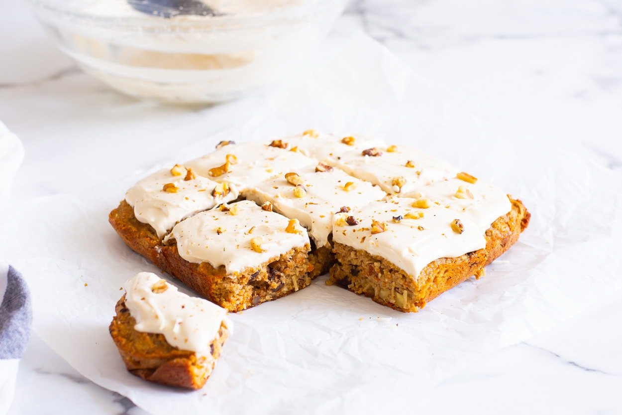 Healthy carrot cake bars sliced with one slice removed from rest.