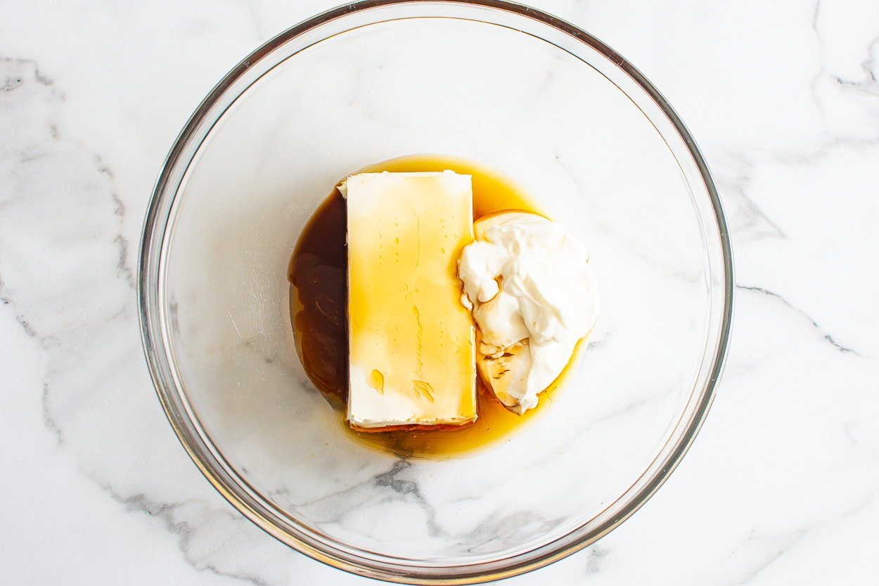 Cream cheese, greek yogurt, maple syrup, vanilla extract in glass bowl.