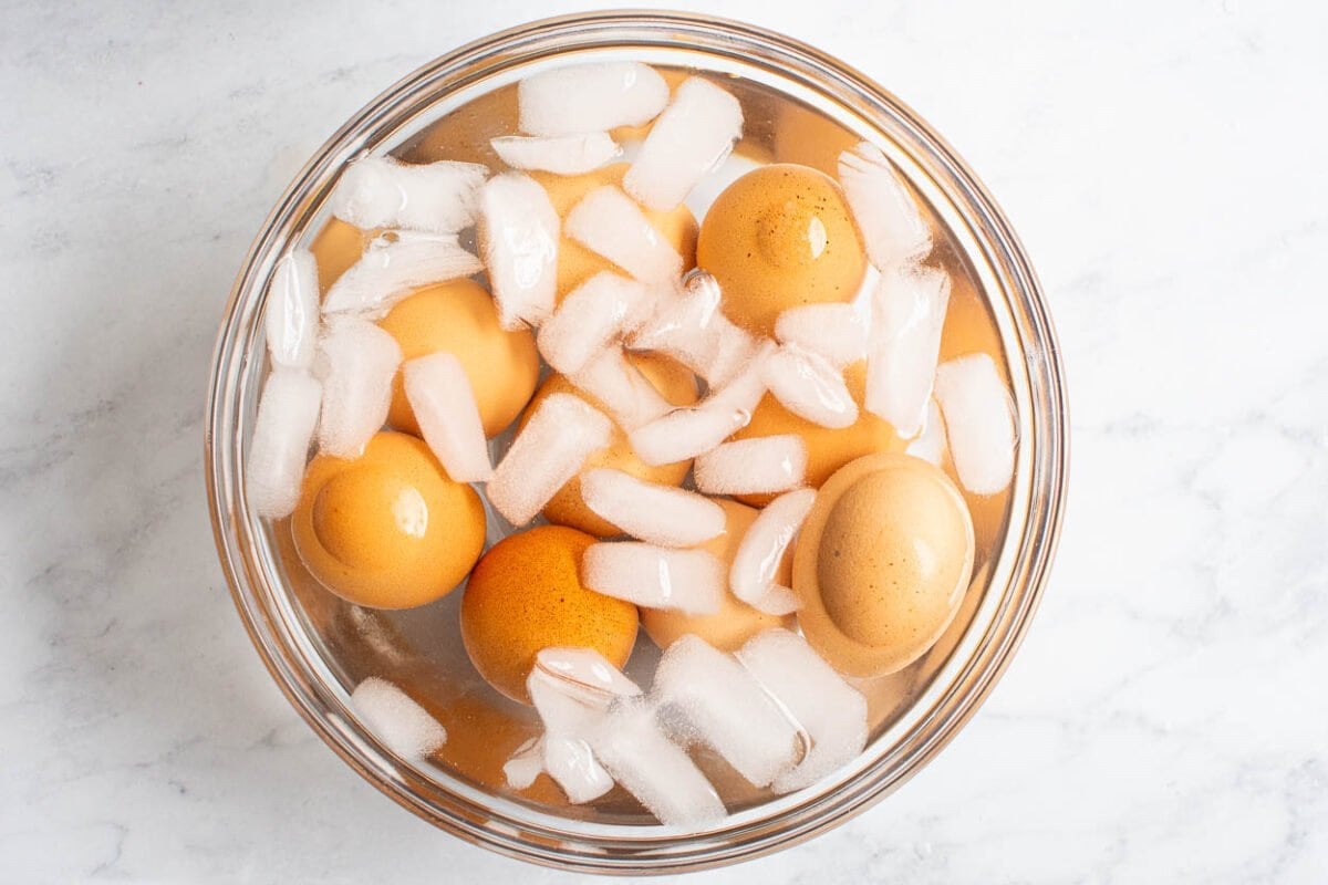 Hard boiled eggs in a bowl with ice and water.