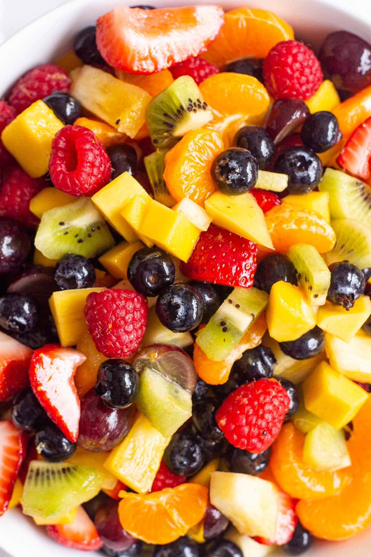 Close up of classic healthy fruit salad with berries, pineapple, mango, grapes and mandarins.