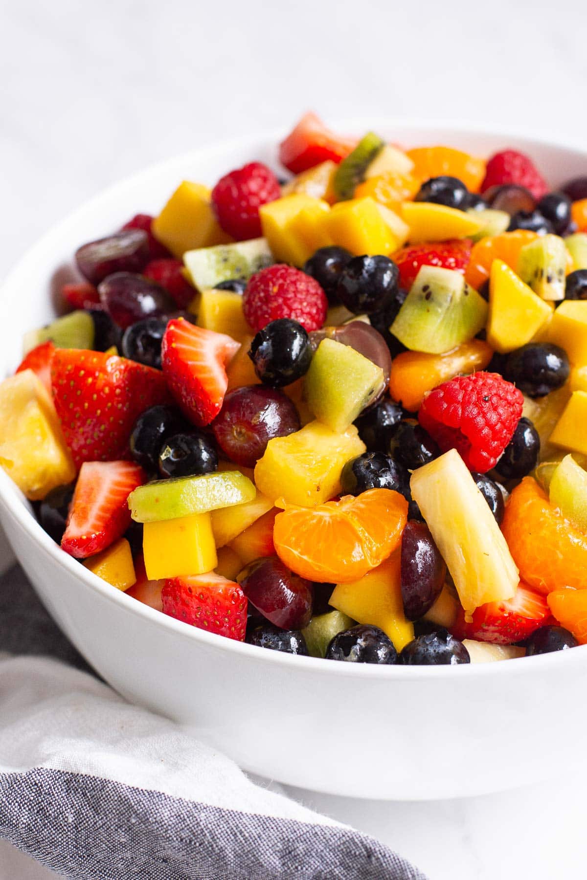 Healthy fruit salad with honey lemon dressing in a bowl.