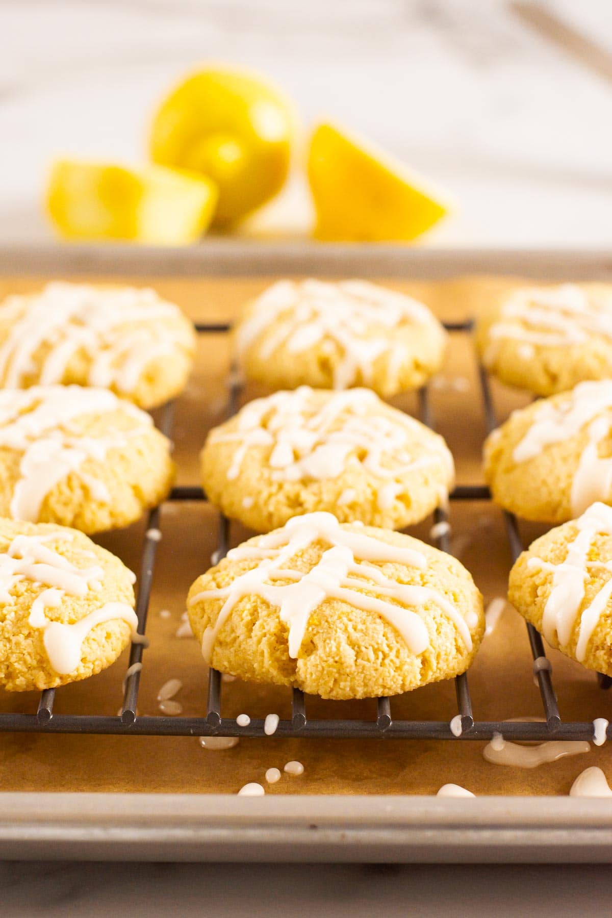 Healthy lemon cookies with almond flour drizzled with icing on baking rack.