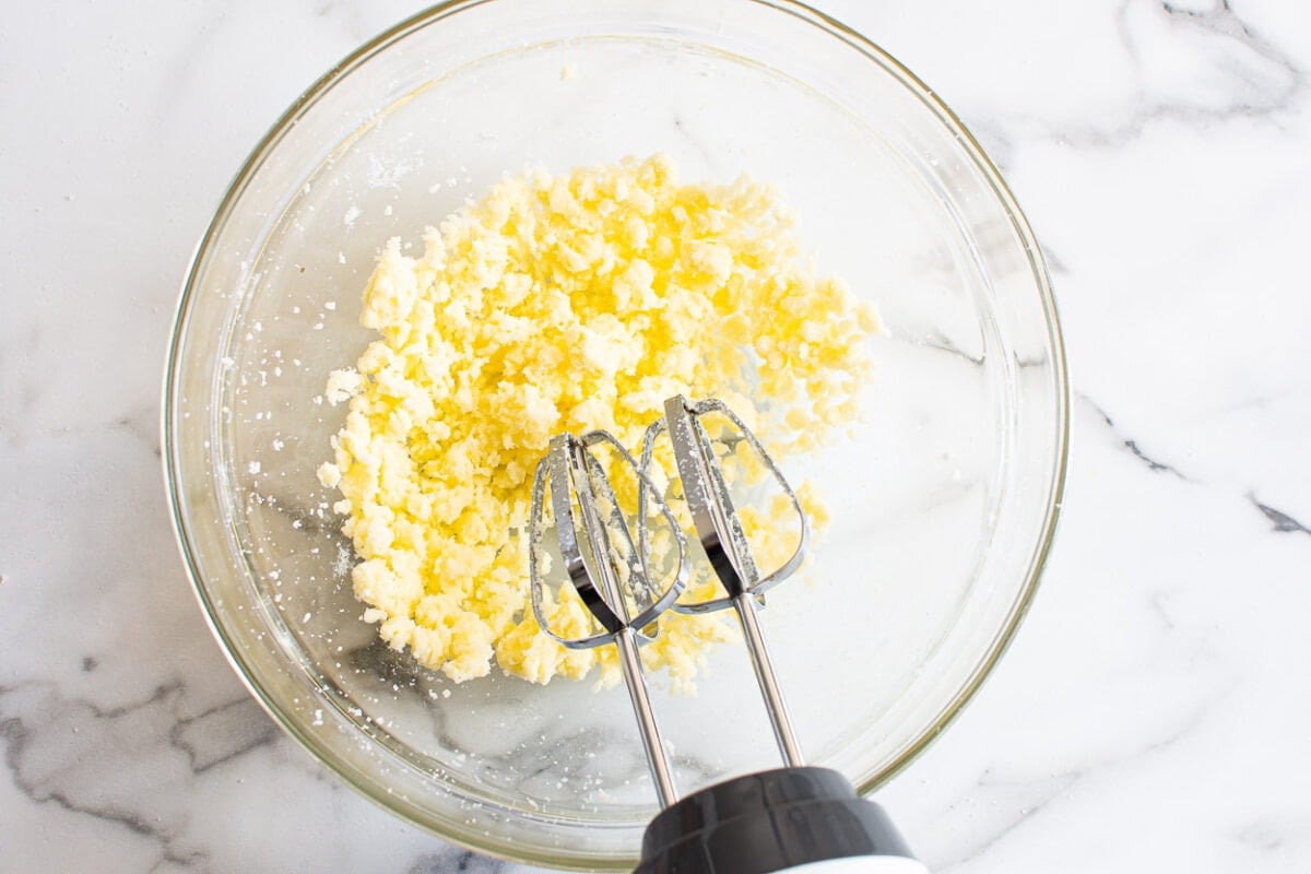 Butter, sugar, lemon zest and juice in bowl with electric mixer.