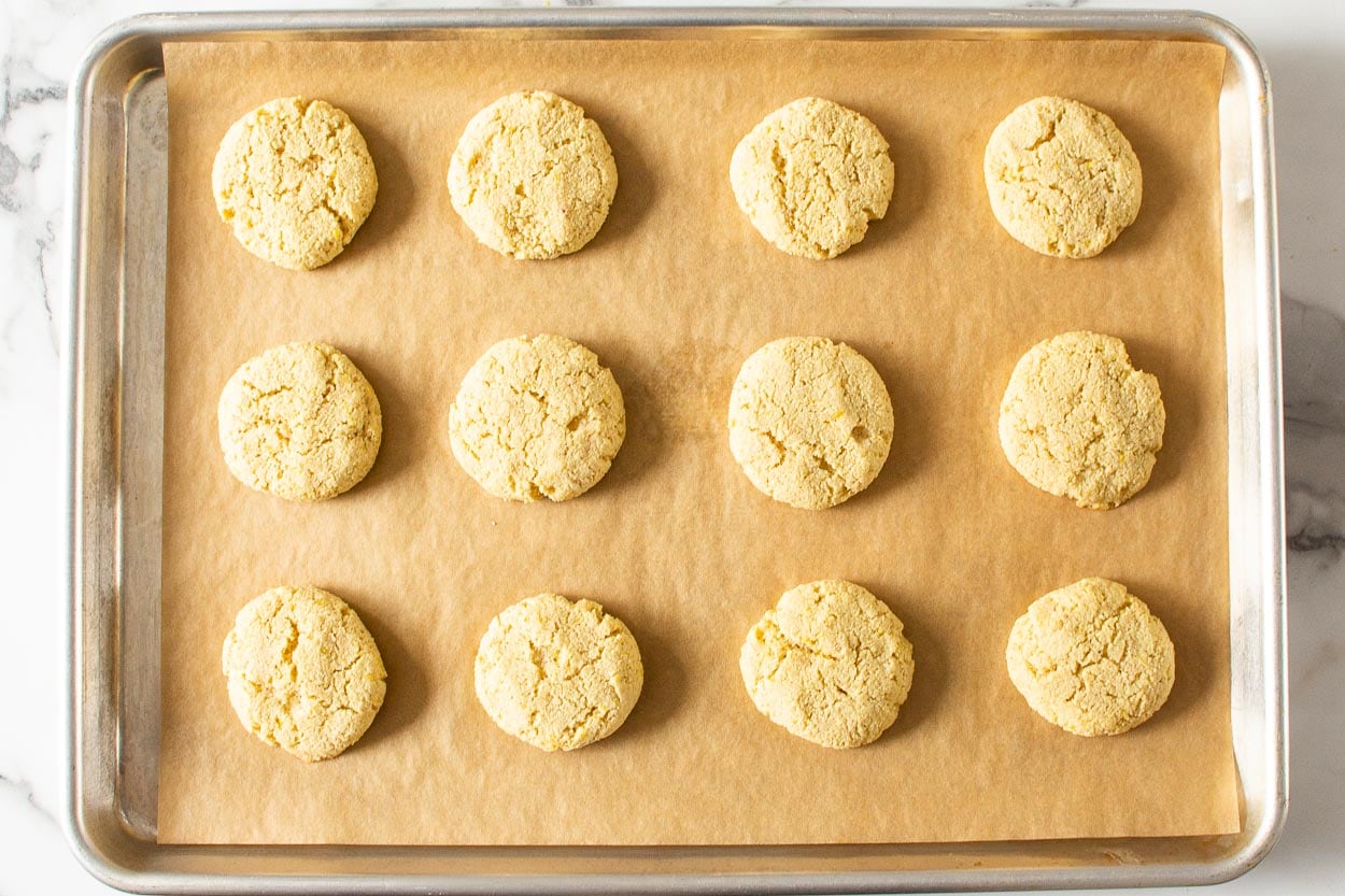 Baked healthy lemon cookies on parchment lined baking sheet.