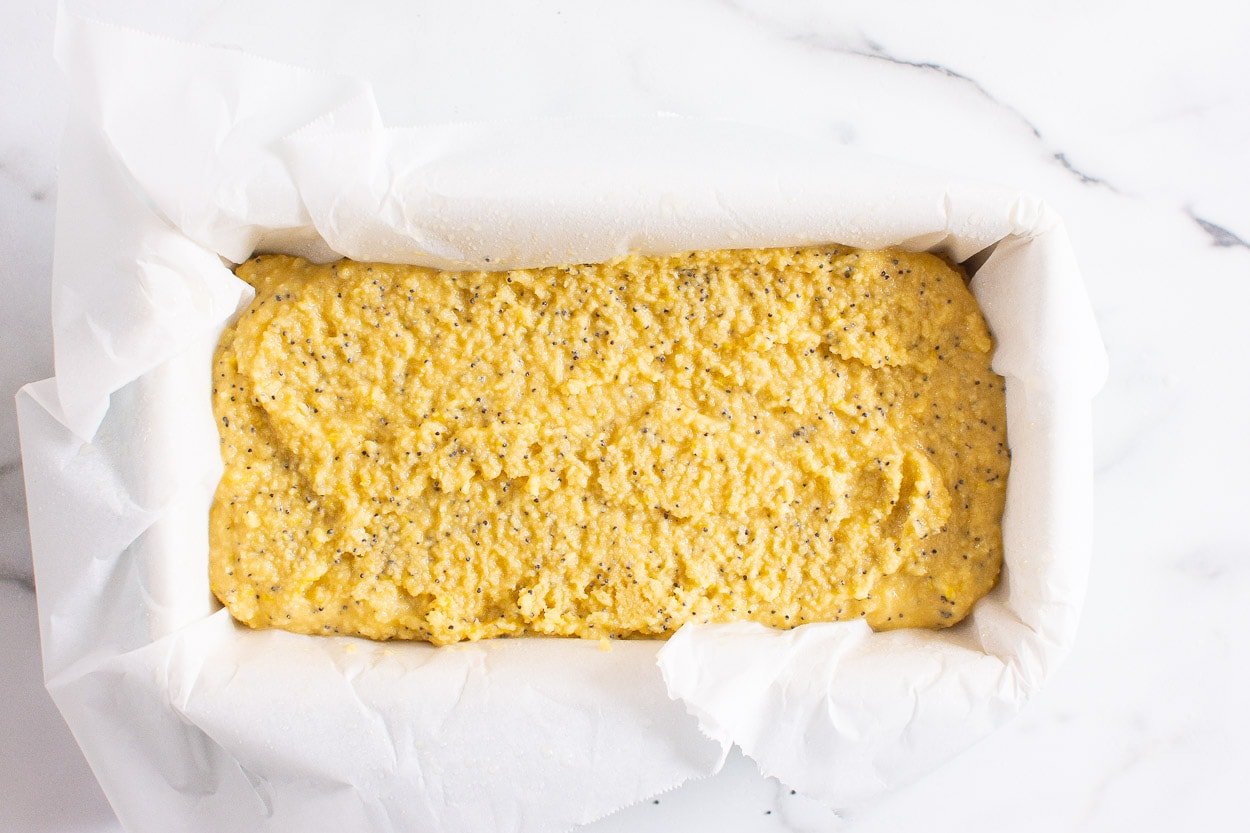 Quick bread batter in a parchment paper lined loaf pan.