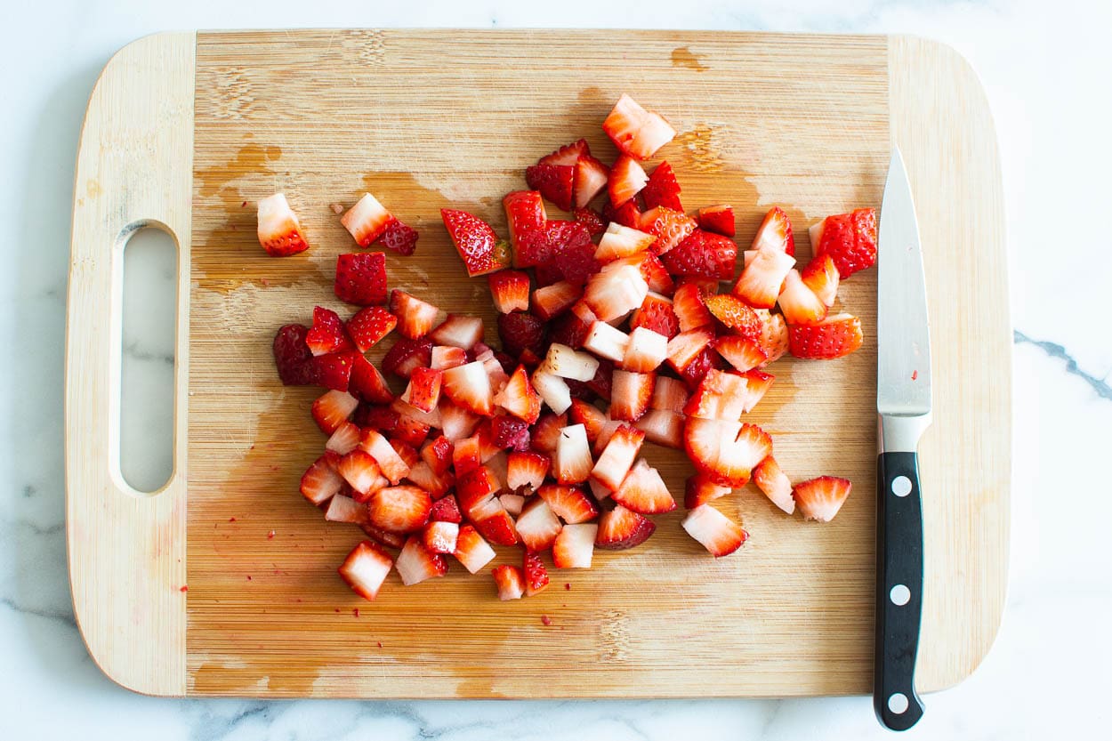 Diced strawberries on a cutting board.
