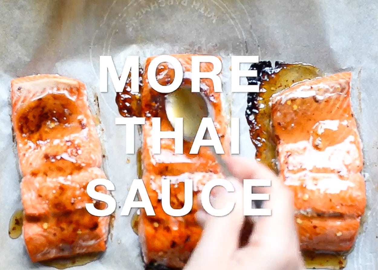 Adding more Thai sauce with a spoon on each salmon fillet mid-point broiling.