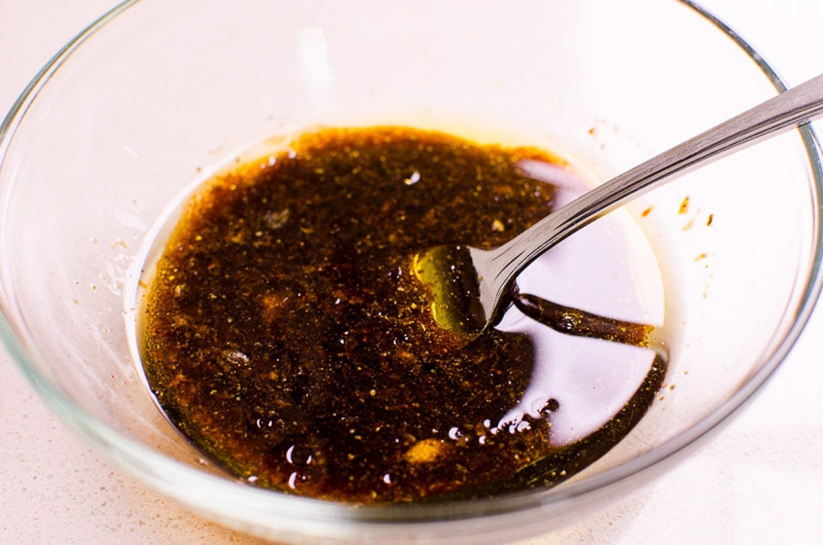 Balsamic, olive oil, garlic, salt and pepper in small bowl with fork.