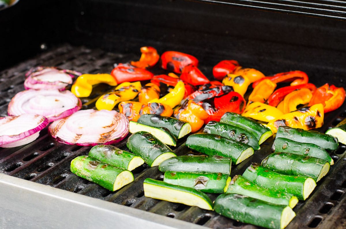 Red onion, bell peppers, and zucchini on grill.