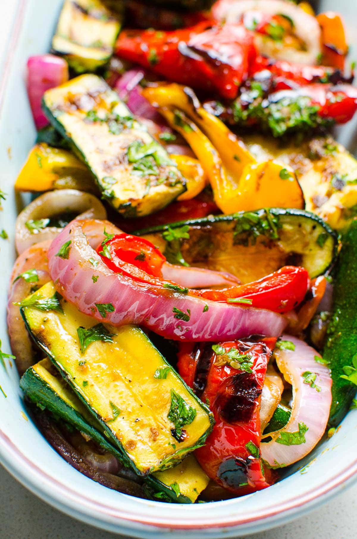 Marinade for grilled vegetables in a serving dish garnished with parsley.