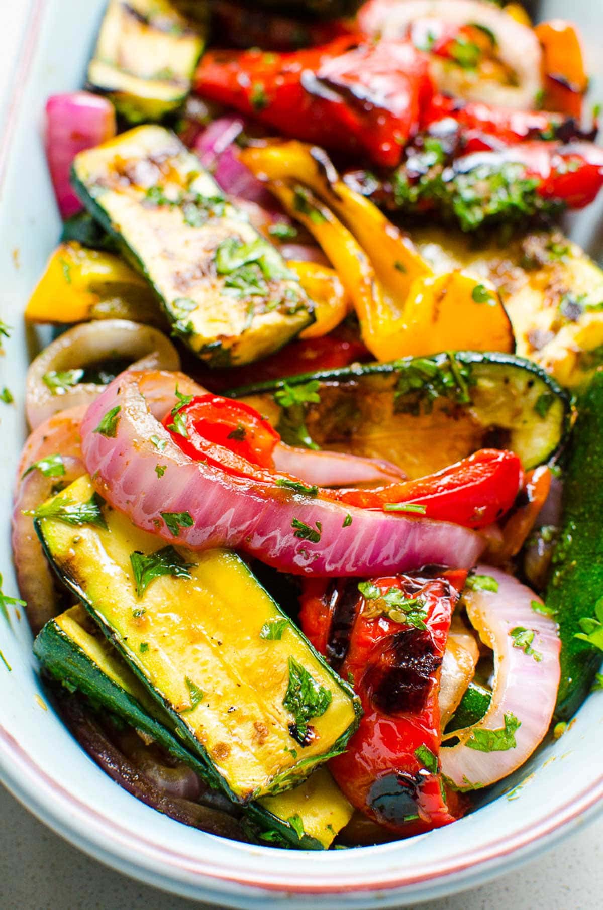 Balsamic grilled vegetables garnished with parsley in a serving dish.