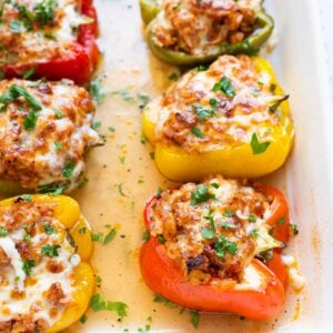 Ground chicken stuffed peppers with rice in baking dish.