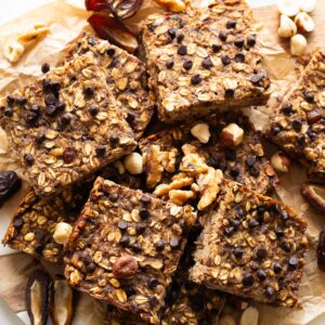 Healthy oatmeal bars garnished with nuts and dates on a serving platter.