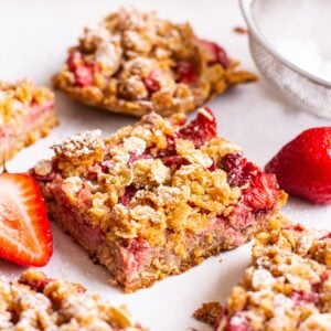 Healthy strawberry oatmeal bars cut into squares with fresh strawberries.