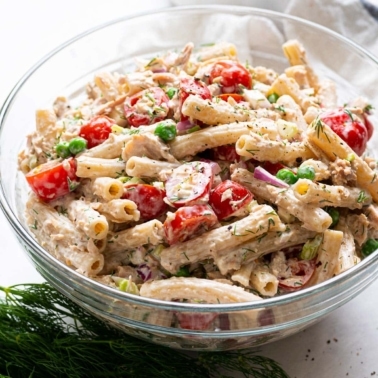 A bowl of healthy tuna pasta salad with sprig of dill.