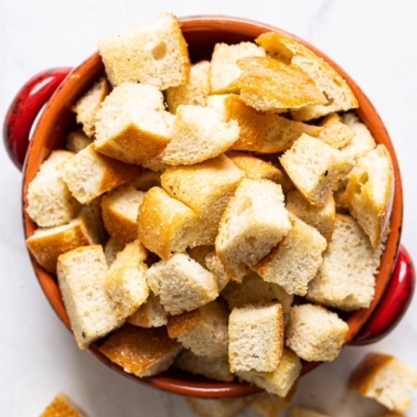 Healthy sourdough croutons in red bowl.