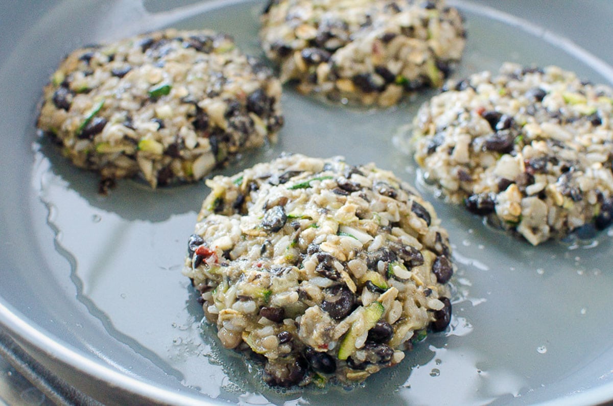 Burgers with black beans and rice in a skillet. 