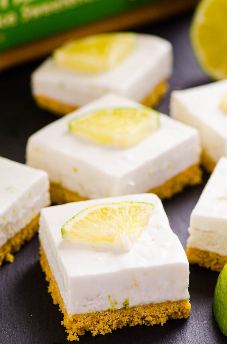 Healthy key lime pie bars with box of corn flakes and fresh lime.